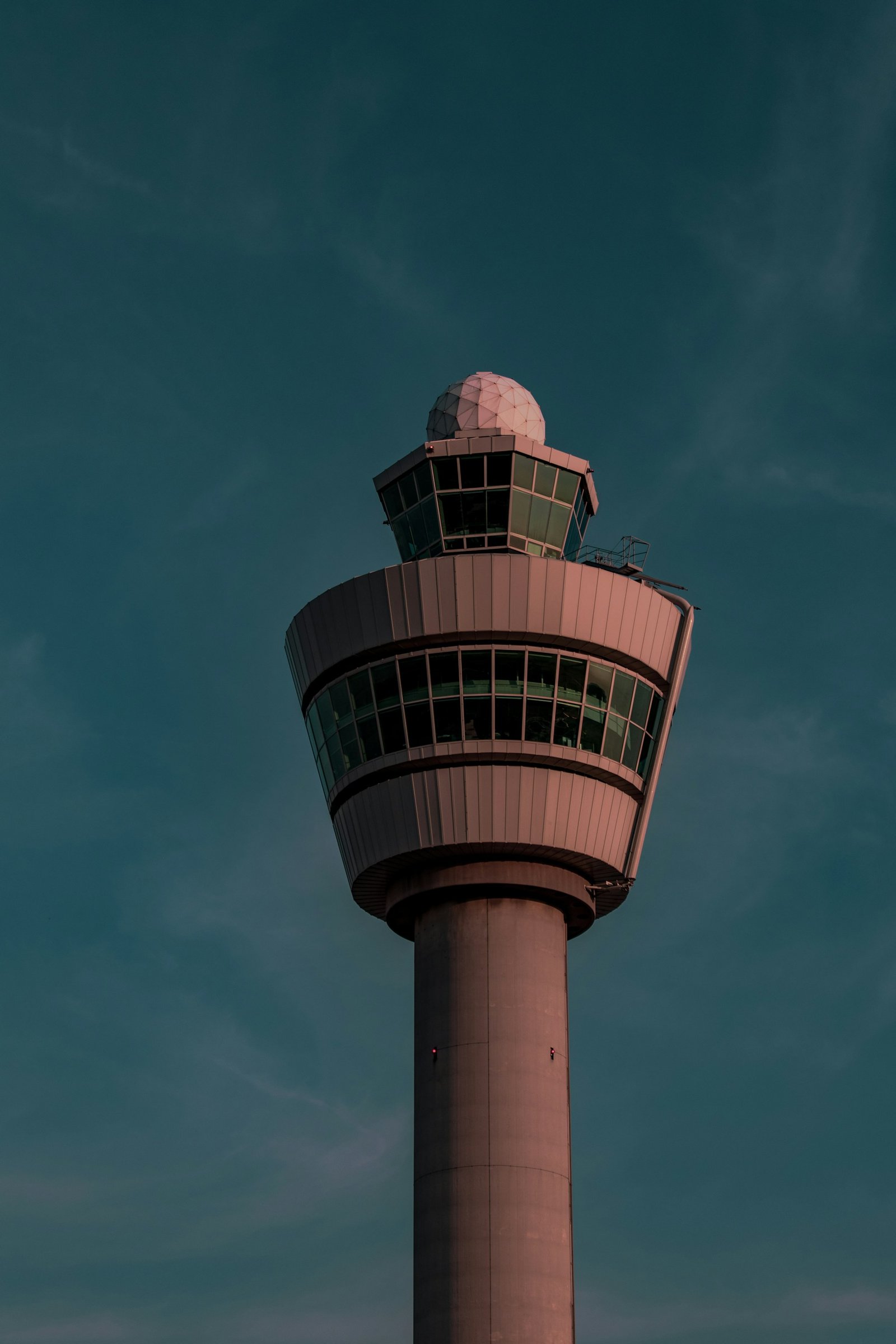 Torre de control aeroportuaria iluminada al anochecer